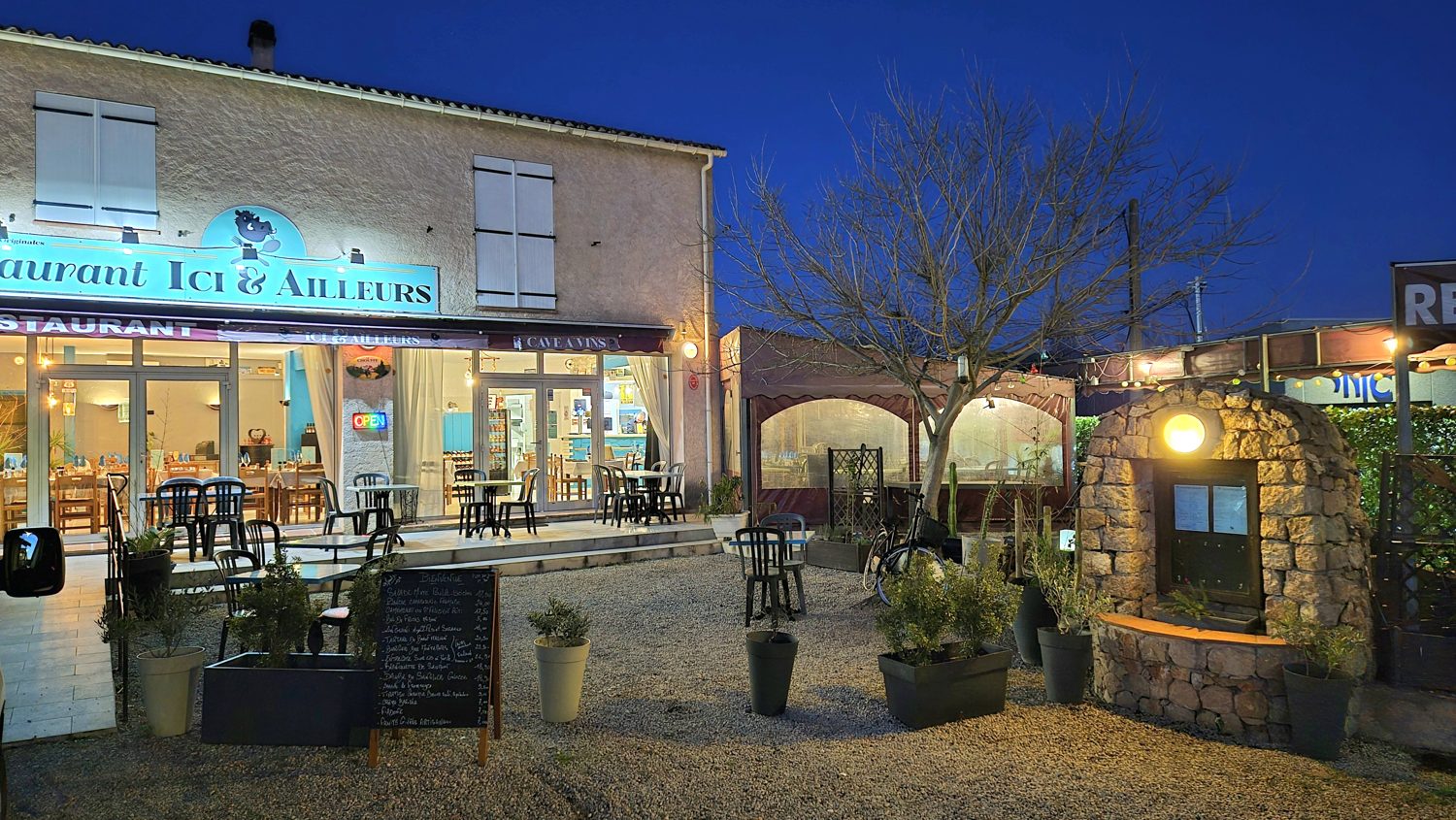 La façade du restaurant éclairée à la tombée de la nuit